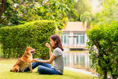 Side view of woman with dog against plants