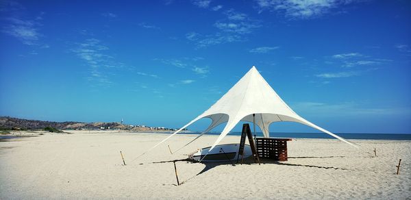 Tent on beach against blue sky on sunny day