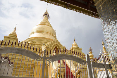 Golden giant stupa under grey skies at kuthodaw pagoda, mandalay