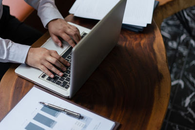 Midsection of man using laptop on table