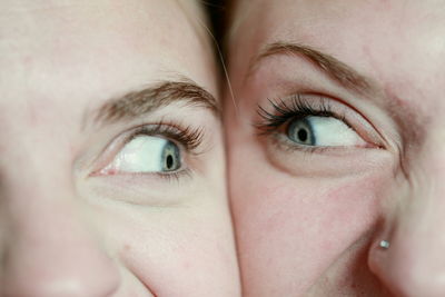 Close-up of young women with cheeks touching looking at each other