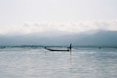 Man on boat in sea against sky