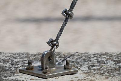 Close-up of tied up rope on metal bollard