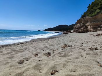 Scenic view of beach against clear blue sky