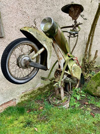 High angle view of old bicycle parked by wall