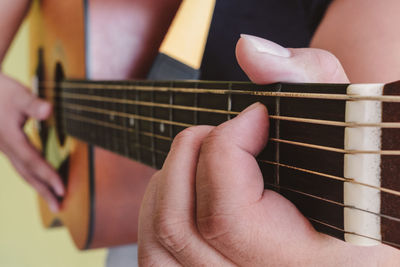 Midsection of person playing guitar