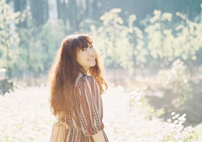 Beautiful young woman standing against blurred background