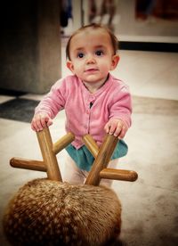 High angle view of cute baby girl standing on floor at home