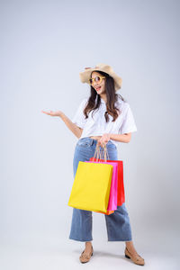 Woman wearing hat standing against white background