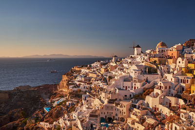 High angle view of townscape by sea against sky during sunset