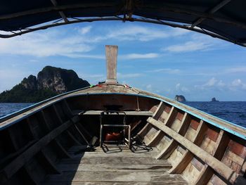 Covered boat on sea against sky