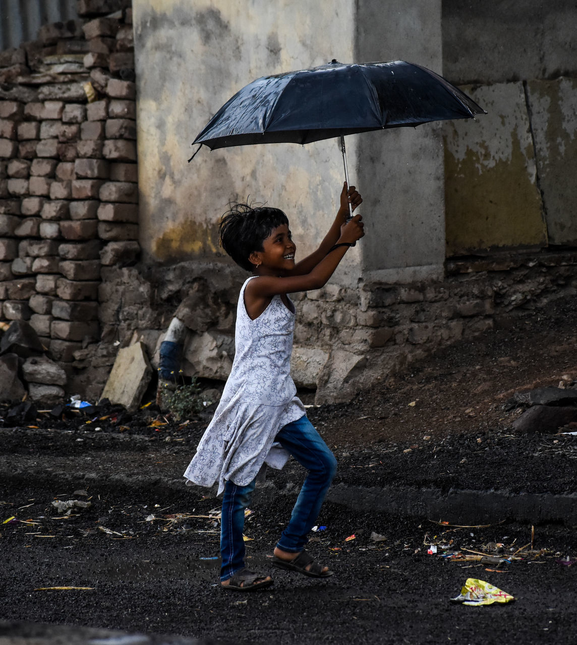 REAR VIEW OF WOMAN HOLDING UMBRELLA STANDING DURING RAINY DAY