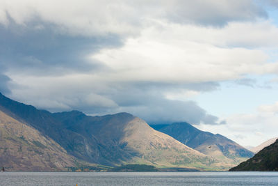 Scenic view of lake by mountains against sky