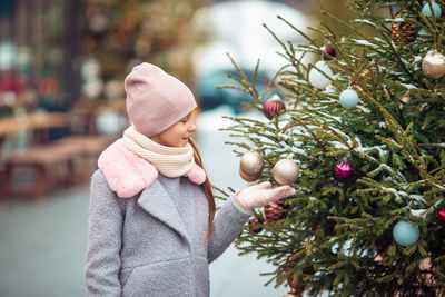 Girl holding christmas tree in winter