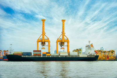 Commercial dock by sea against sky