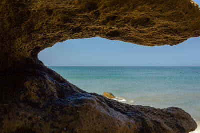 Close-up of rock formation by sea against sky