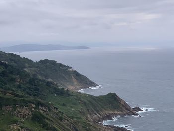 Scenic view of sea and mountains against sky