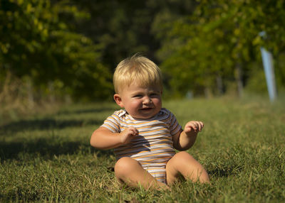 Portrait of happy baby boy on grassy field