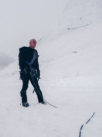 Low angle view of hiker standing on snow