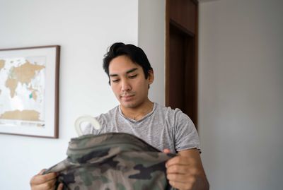 Latin man holding his camo jacket