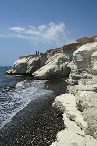 Rocks on beach against sky