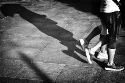 Low section of woman standing on tiled floor