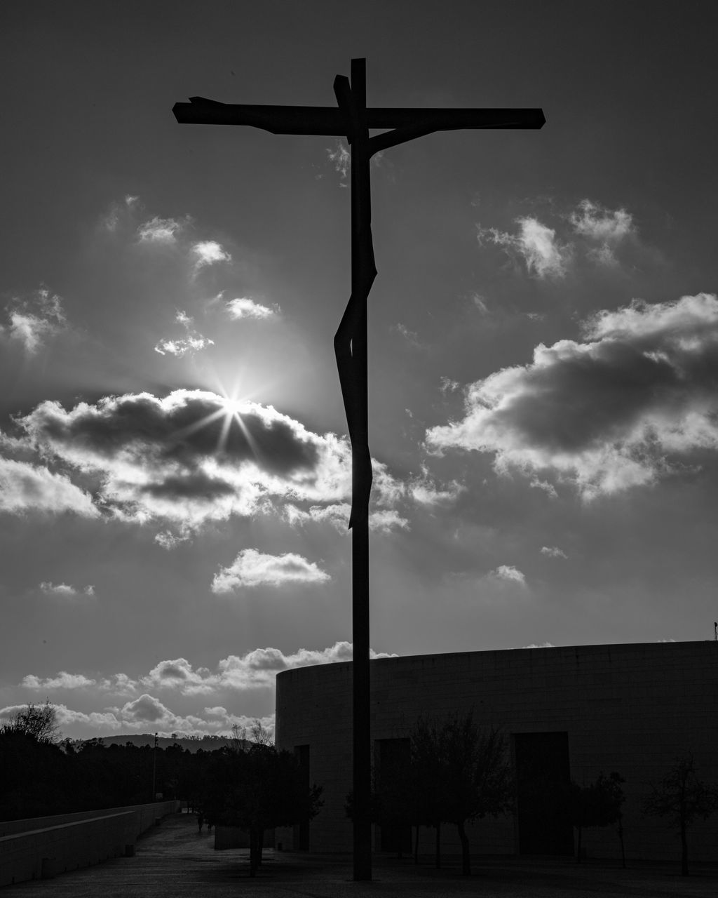 sky, cross, black and white, cloud, religion, belief, spirituality, symbol, monochrome, darkness, nature, crucifix, monochrome photography, silhouette, architecture, catholicism, no people, place of worship, cross shape, street light, cloudscape, environment, storm, outdoors, built structure, dramatic sky, low angle view, black, tranquility, beauty in nature
