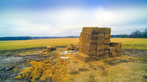 Hay bales on field against sky