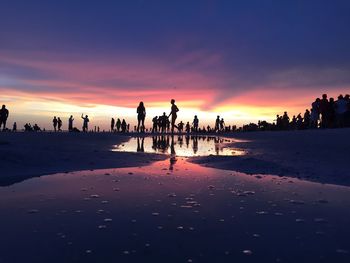 People at beach during sunset