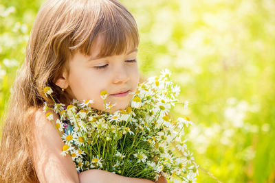 Side view of girl blowing flowers