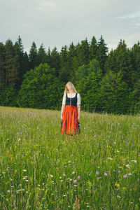 Rear view of woman standing on field