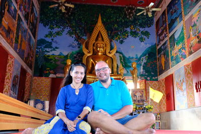 Portrait of a smiling couple sitting in thai temple