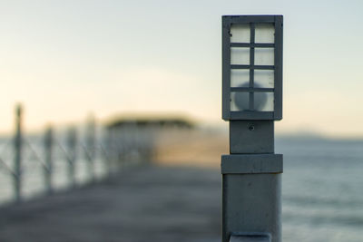 Close-up of wooden post at beach against sky during sunset