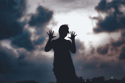 Low angle view of silhouette woman against sky at sunset