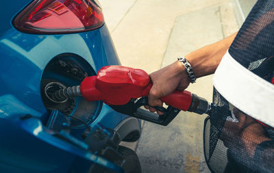 Car fueling at gas station. refuel fill up with petrol gasoline. petrol pump filling fuel nozzle 