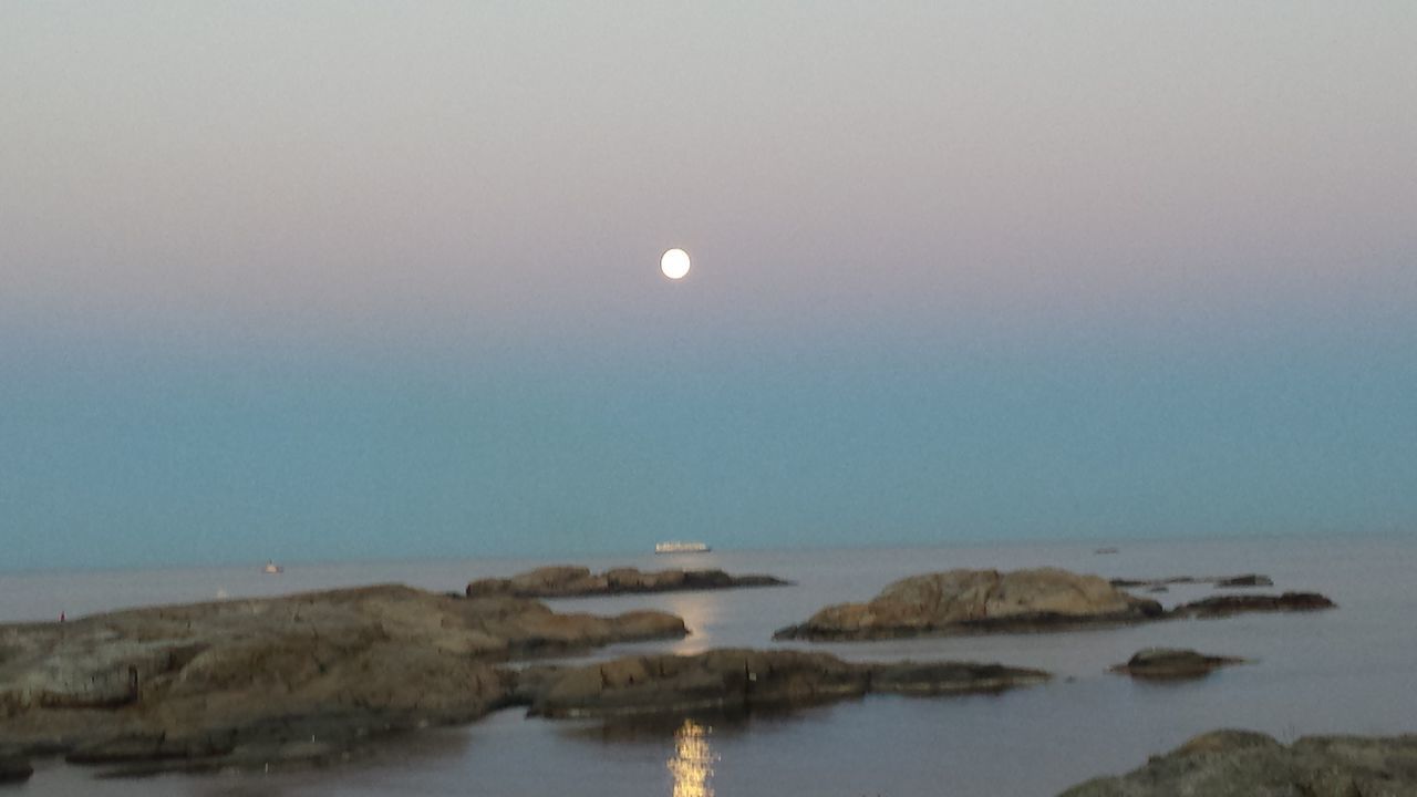 sea, water, horizon over water, tranquil scene, tranquility, scenics, clear sky, copy space, beauty in nature, nature, sky, idyllic, rock - object, waterfront, beach, moon, shore, dusk, calm, reflection