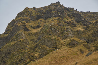 Low angle view of rocks on mountain against sky