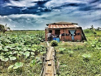 View of abandoned house against cloudy sky