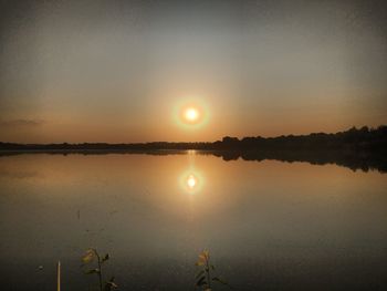 Scenic view of lake against sky during sunset