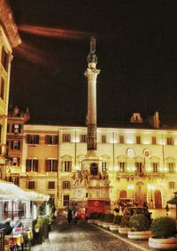 Statue in city at night