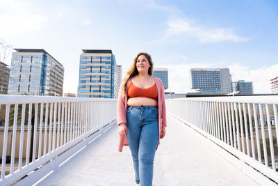 Young woman walking on footbridge