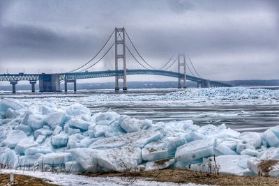 Bridge over sea against sky during winter