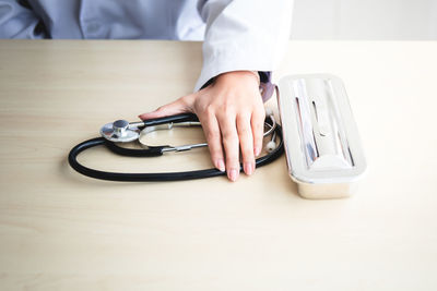 Midsection of person holding smart phone on table