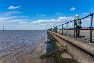 Person standing on jetty against sea