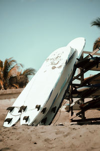 Close-up of deck chairs on beach against clear sky