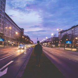 Rear view of man walking on street at night