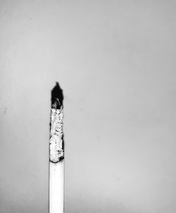 Close-up of cigarette smoking against wall