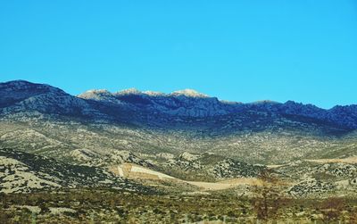 Scenic view of mountains against clear blue sky