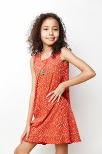 Portrait of young woman standing against white background