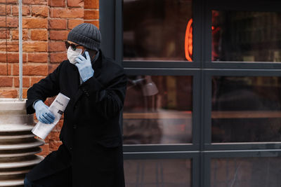 Man looking away while talking on phone outdoors